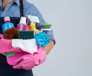 young-girl-is-holding-cleaning-product-gloves-rags-basin-white-wall-scaled.jpg